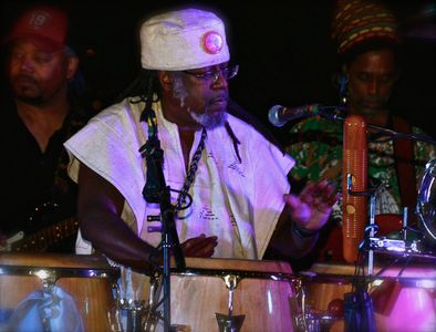 Man playing conga drums at a live music event.